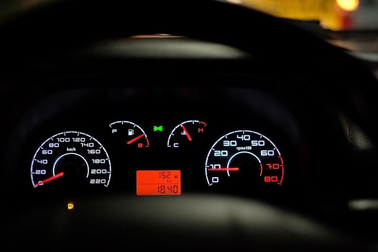 Dashboard hazard-light switch illuminated inside a vehicle stopped on the shoulder