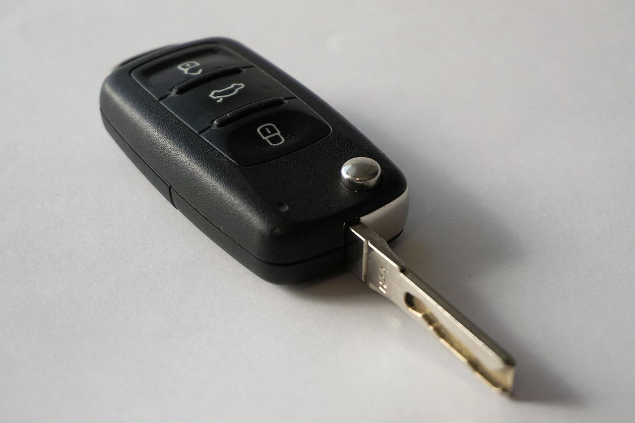 Tech handing keys back to driver on I-95 shoulder at night, red emergency strip light reflecting on wet asphalt