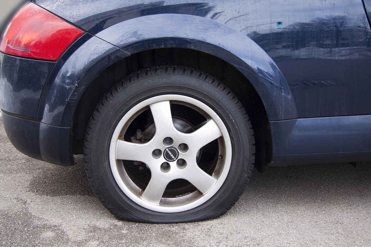 Flat tire with sidewall damage on a parked car